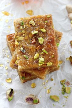 three pieces of food sitting on top of a piece of wax paper next to nuts