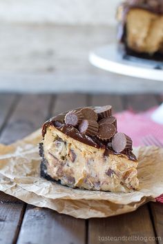 a slice of chocolate chip cheesecake on a piece of parchment paper next to a fork