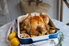 a chicken in a blue and white dish with lemons