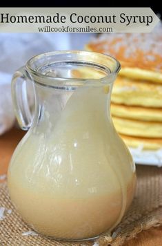 homemade coconut syrup in a glass pitcher on a table with crackers and napkins