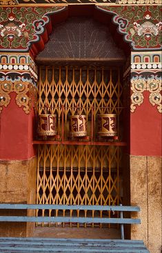 a wooden bench sitting in front of a building with decorative designs on it's walls