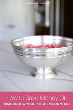 a silver bowl filled with raspberries sitting on top of a white countertop