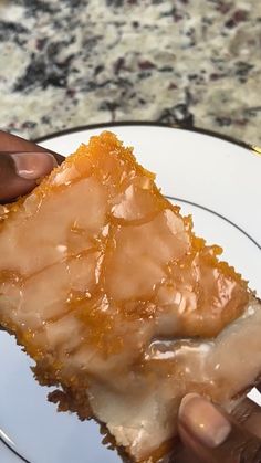 a person holding onto a piece of food on a plate