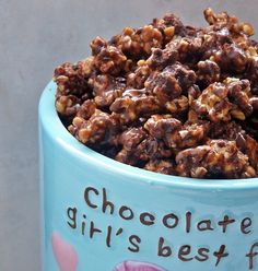 a blue bowl filled with chocolate and nuts