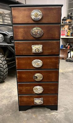 a wooden dresser with metal knobs on it's drawers in a garage next to a truck