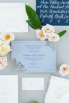 the wedding stationery is laid out with flowers