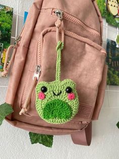 a pink backpack with a green frog face on it