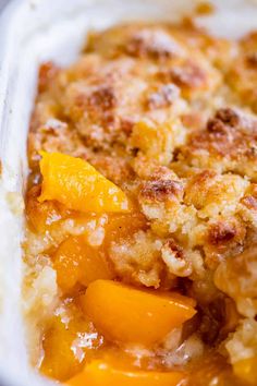 a casserole dish with peaches and crumbled toppings on top