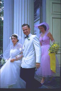 a man and woman dressed in wedding attire standing next to each other on the steps