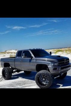 a gray truck parked on top of a sandy beach