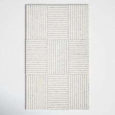 a white wall hanging on the side of a wall with an abstract pattern in it