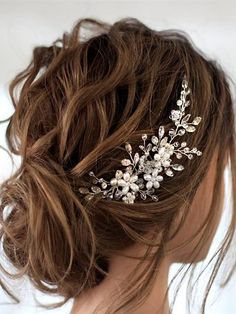 a woman wearing a bridal hair comb with flowers on it's back side