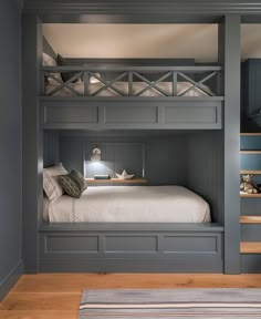 a bunk bed is built into the side of a gray painted room with stairs leading up to it