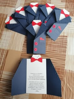 an origami piece of paper with red and white bow ties on it