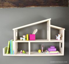 a shelf with books and toys on it in front of a wall mounted bookcase