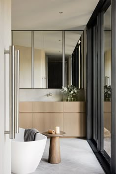 a bathtub sitting in the middle of a bathroom next to a tall glass wall