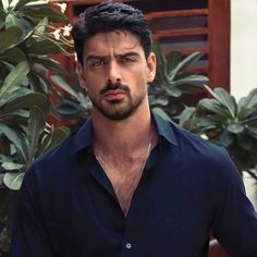 a man standing in front of some plants