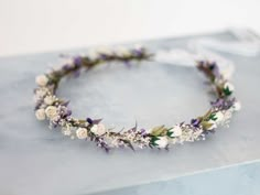 a white and purple flower crown on top of a table