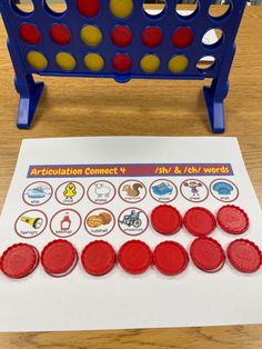 a game board with red and yellow buttons on it next to a white piece of paper that says anciliation connect