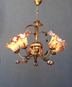 a chandelier with flowers hanging from it's center and two lights on each side