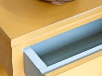 a donut sitting on top of a wooden counter next to a microwave oven door