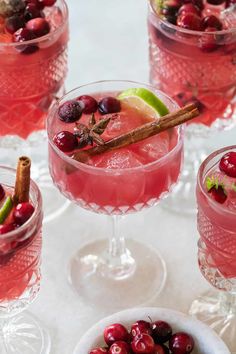 three glasses filled with cranberry punch garnished with cinnamon and anisette