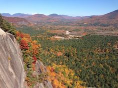 an aerial view of trees and mountains in the fall with autumn foliage on the rocks