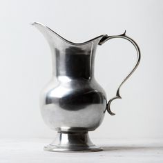 a silver pitcher sitting on top of a table