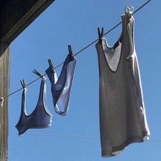 two bras hanging on a clothes line with blue sky in the backround