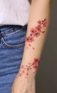 a woman's arm with red flowers tattooed on the left side of her arm