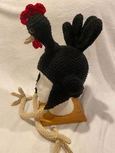 a knitted hat with a rooster head on top of a mannequin's head