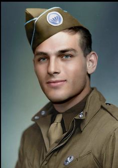 a man in uniform is posing for a photo with a hat on top of his head