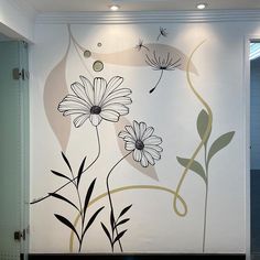 a white wall with flowers painted on it in an office building, next to a closed door