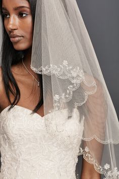 a woman in a wedding dress with a veil over her head