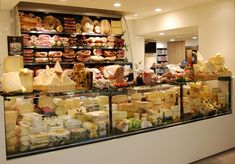 a store filled with lots of different types of cheeses and meats on display