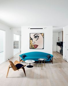 a living room filled with furniture and a painting on the wall