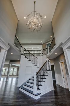 a chandelier hangs from the ceiling above a staircase