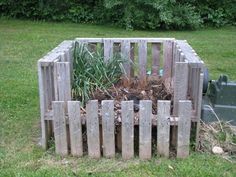 a wooden fence with plants growing out of it in the middle of some grass next to a fire hydrant