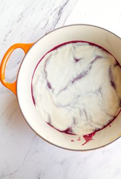 a bowl filled with liquid sitting on top of a white counter