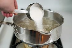 a person is stirring something in a pot on the stove