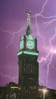 a clock tower with lightning in the background