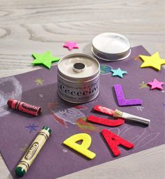 some crafting supplies are laying out on a purple piece of paper with letters and stars