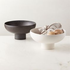 two black and white bowls sitting next to each other