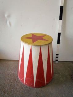 a red and white circus hat sitting on top of a floor next to a wall