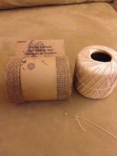 two rolls of twine sitting on top of a couch next to a ball of yarn