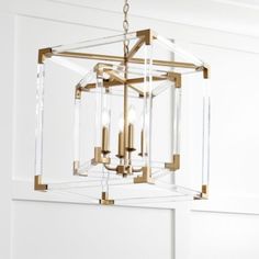 a chandelier hanging from the ceiling with clear glass blocks and gold trimmings