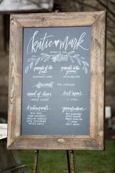 a chalkboard sign with the names of different wedding ceremony programs on it in front of a grassy area