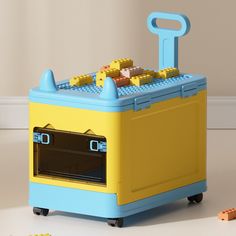 a yellow and blue toy oven sitting on top of a white table next to toys