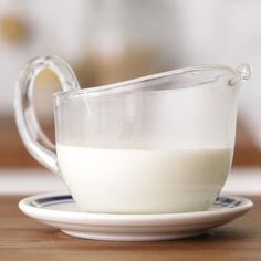 a glass pitcher filled with milk on top of a plate