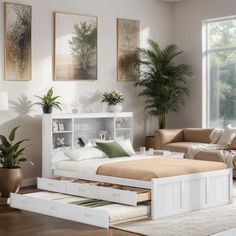 a white bed with drawers underneath it in a room next to a couch and coffee table